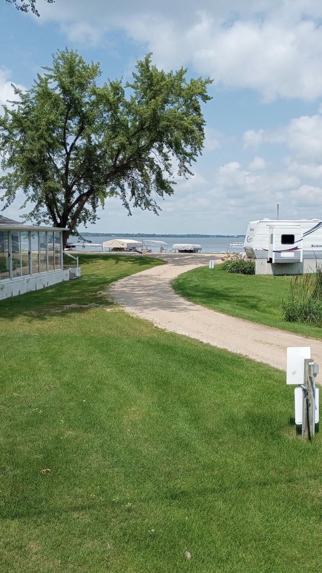 surrounding community featuring a water view and a yard