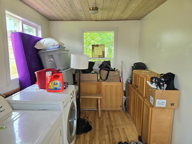 washroom with wooden ceiling, washer and clothes dryer, light hardwood / wood-style floors, and cabinets