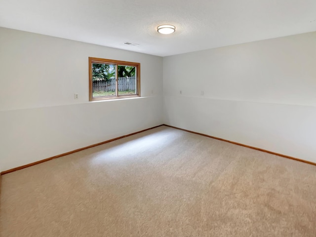 unfurnished room with carpet and a textured ceiling