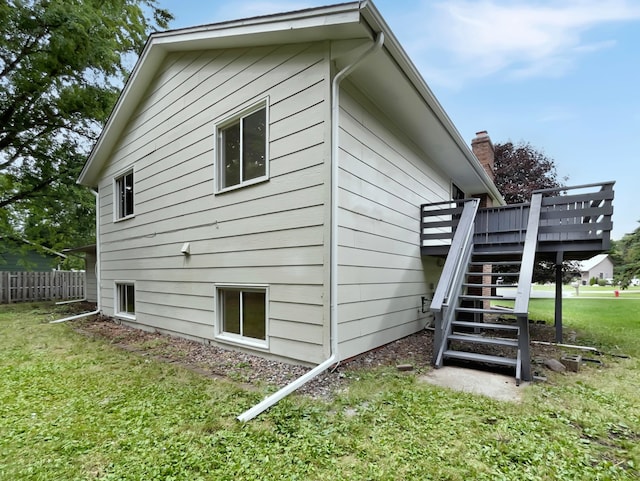 view of side of property with a wooden deck and a lawn