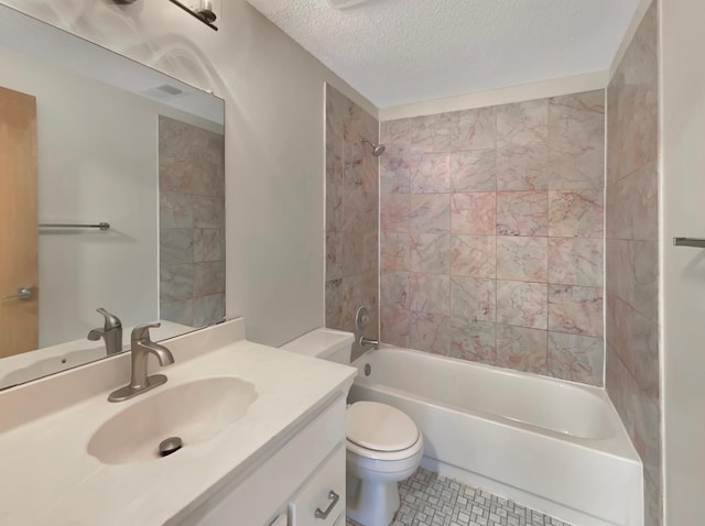 full bathroom featuring vanity, tiled shower / bath, toilet, a textured ceiling, and tile patterned flooring