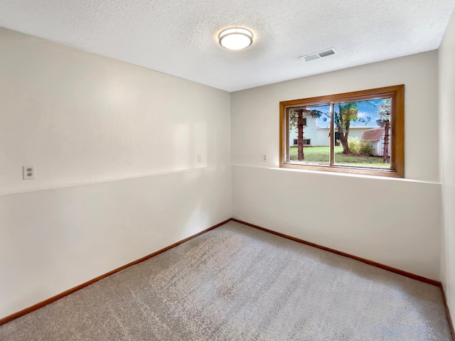 unfurnished room featuring carpet and a textured ceiling