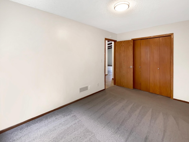 unfurnished bedroom with light carpet and a closet