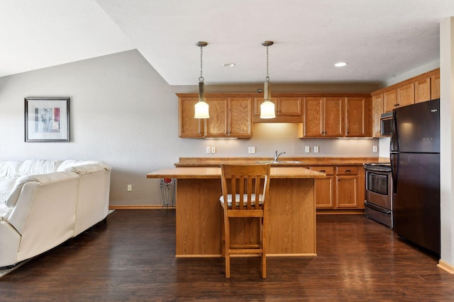 kitchen featuring sink, decorative light fixtures, a center island, dark hardwood / wood-style floors, and black appliances