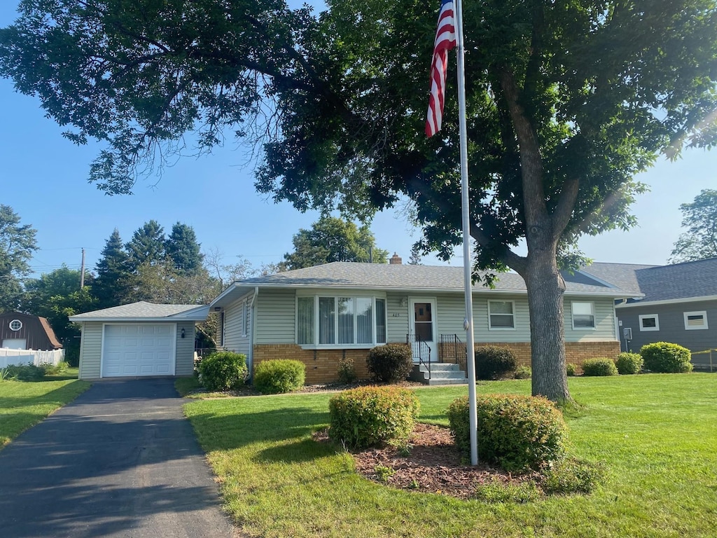 single story home with an outbuilding, a garage, and a front yard