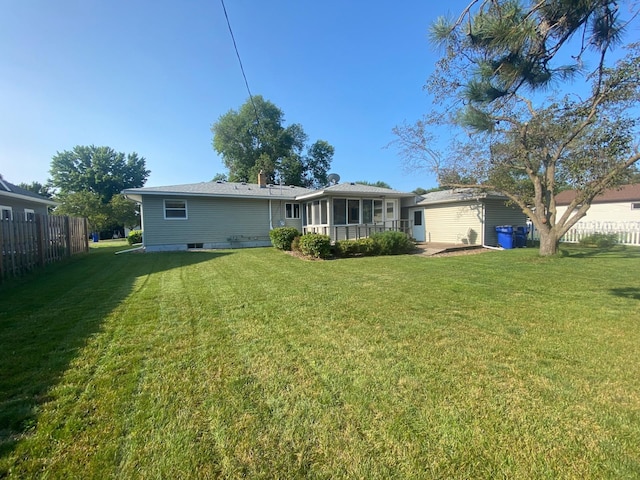 rear view of property featuring a lawn