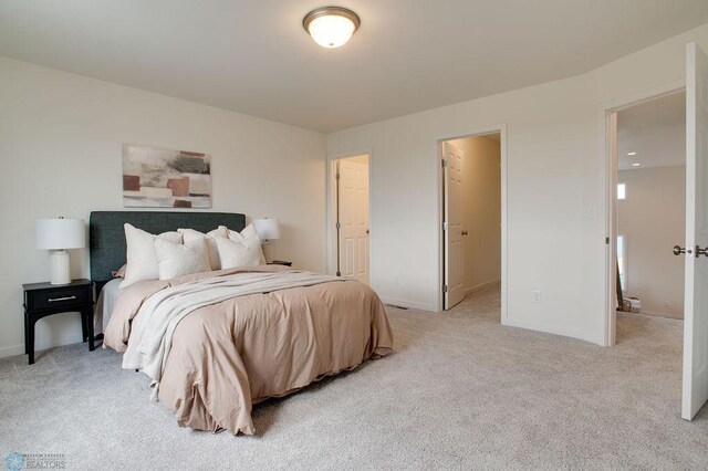 bedroom featuring a spacious closet, light colored carpet, and a closet