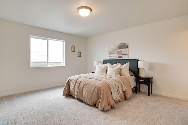 bedroom featuring baseboards and light carpet