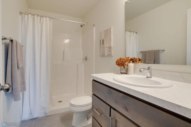 full bathroom with toilet, a stall shower, and vanity