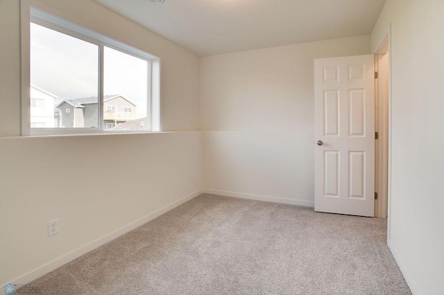 empty room featuring carpet flooring and baseboards