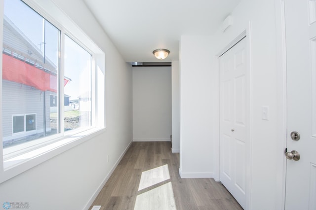 hall with baseboards and light wood-style flooring