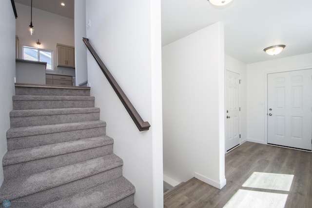 stairs with recessed lighting, baseboards, and wood finished floors