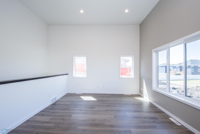 unfurnished room featuring plenty of natural light, recessed lighting, dark wood finished floors, and visible vents