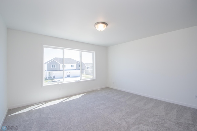 carpeted empty room featuring baseboards