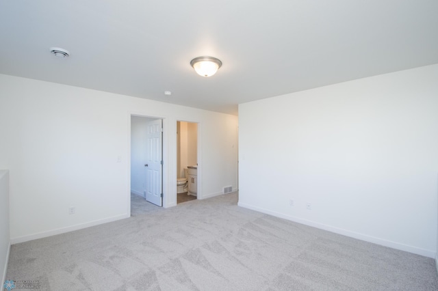 unfurnished room with baseboards, visible vents, and light carpet