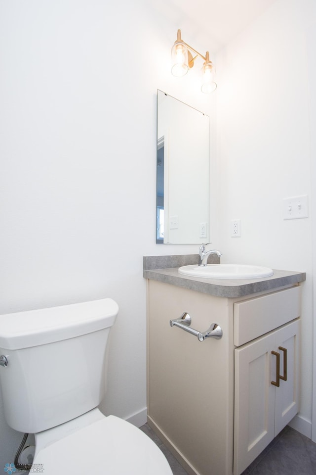 half bathroom featuring vanity and toilet