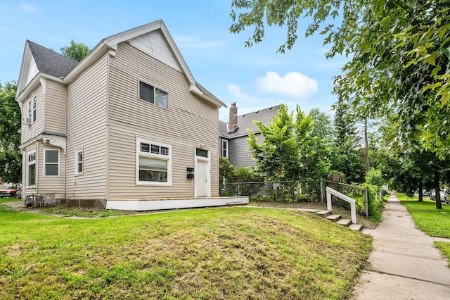 rear view of house featuring a lawn