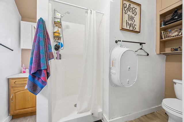 bathroom featuring hardwood / wood-style flooring, vanity, toilet, and walk in shower