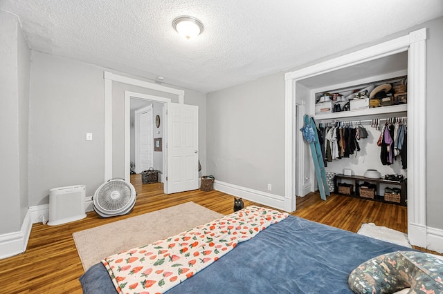 bedroom featuring a textured ceiling, a closet, and dark hardwood / wood-style flooring