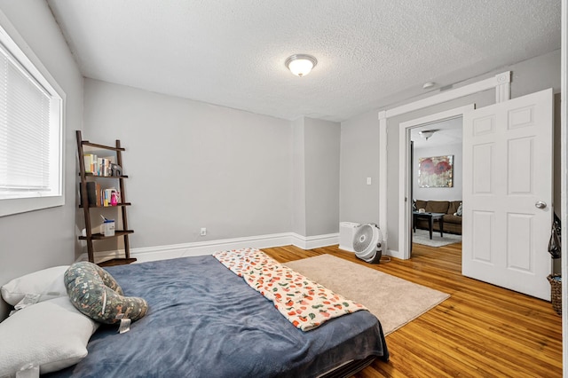 bedroom with wood-type flooring and a textured ceiling