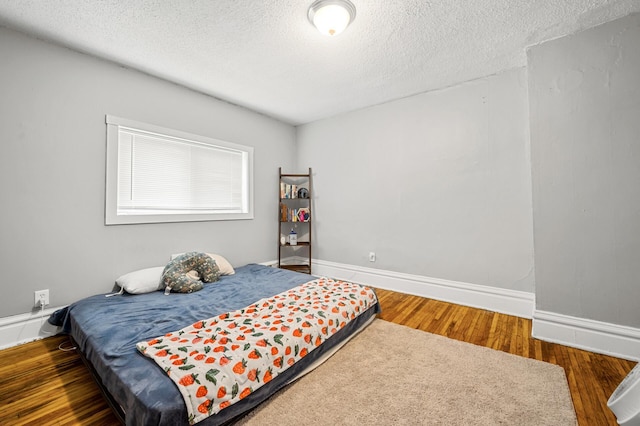 bedroom with dark hardwood / wood-style flooring and a textured ceiling