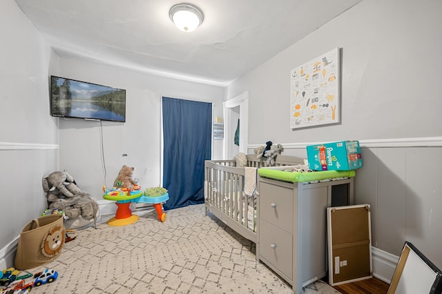 bedroom with a nursery area and light hardwood / wood-style floors