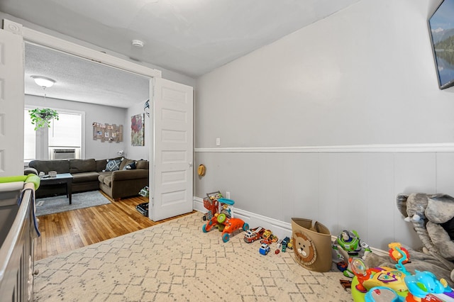 rec room featuring wood-type flooring and a textured ceiling