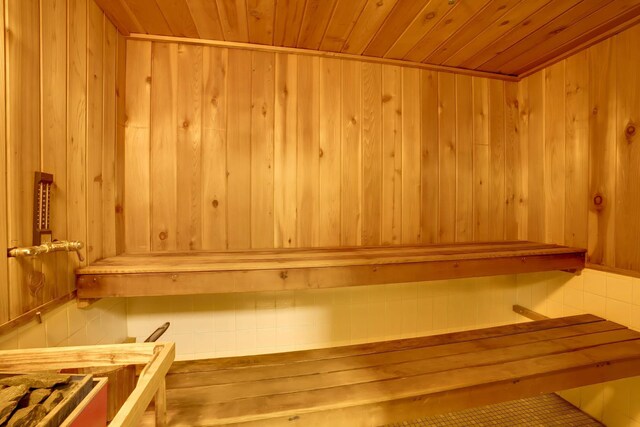 view of sauna featuring wooden walls and wooden ceiling