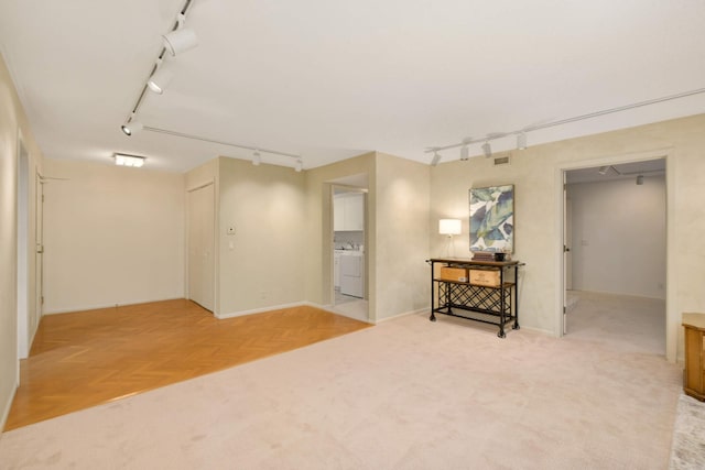 basement featuring parquet flooring and washer and dryer