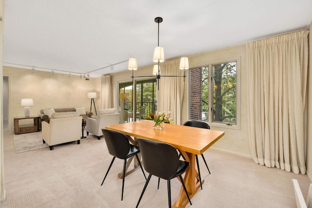 carpeted dining space featuring rail lighting