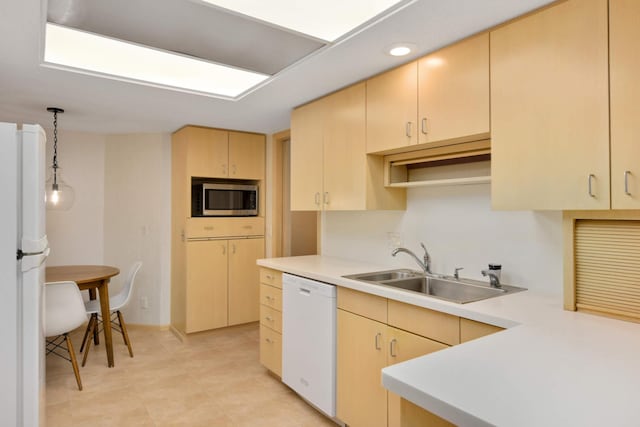 kitchen featuring white appliances, sink, kitchen peninsula, pendant lighting, and light brown cabinets