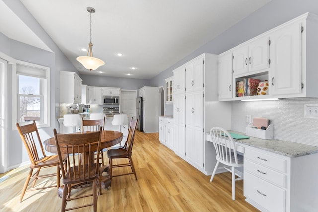 dining area featuring recessed lighting, baseboards, light wood-style flooring, and built in desk