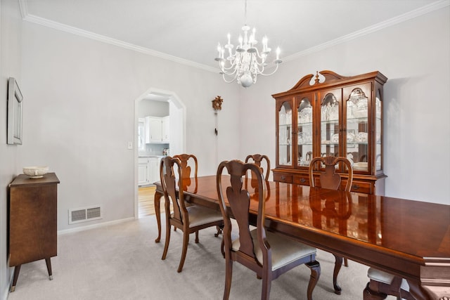 dining space featuring arched walkways, visible vents, light carpet, and ornamental molding