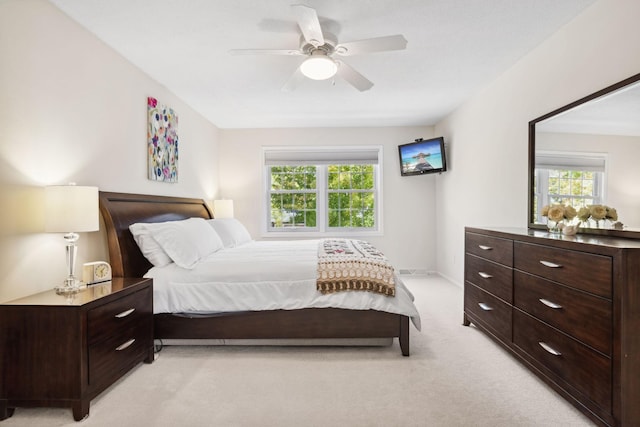 bedroom with light colored carpet, baseboards, and ceiling fan