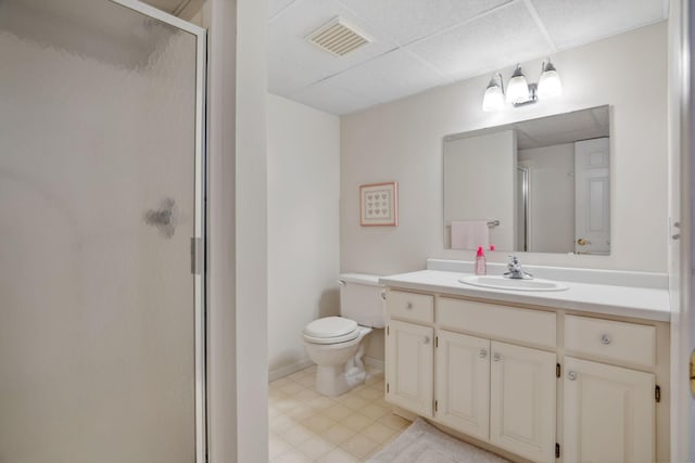 bathroom with vanity, a shower stall, toilet, and visible vents