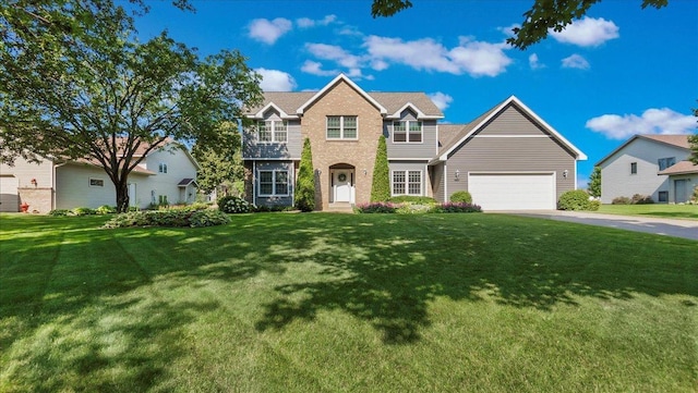 view of front of property with a front lawn, an attached garage, and driveway