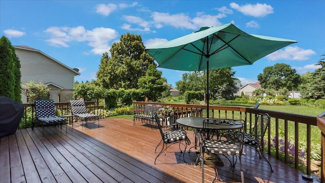 wooden deck with a lawn and outdoor dining space