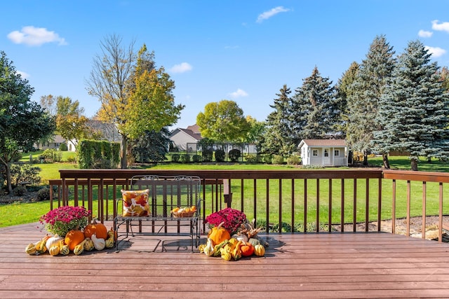 wooden terrace with a yard and an outdoor structure