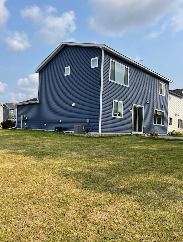 back of house featuring a yard and central AC unit