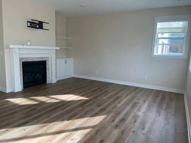 unfurnished living room featuring wood-type flooring and a fireplace