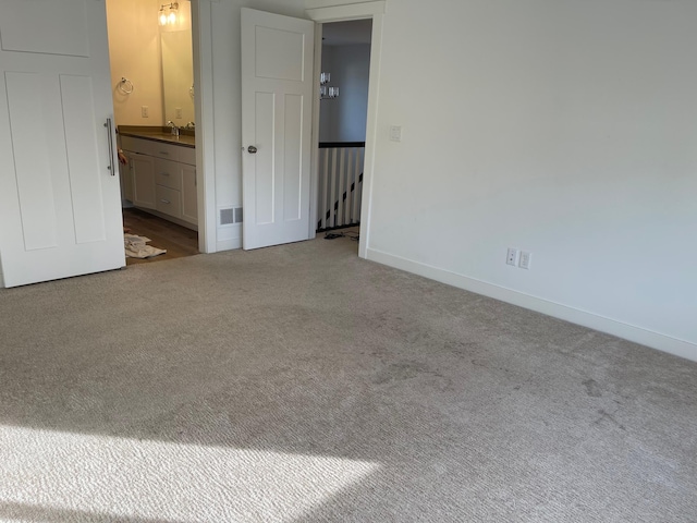 empty room featuring light colored carpet and sink