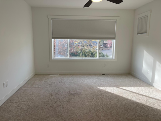 carpeted spare room featuring ceiling fan