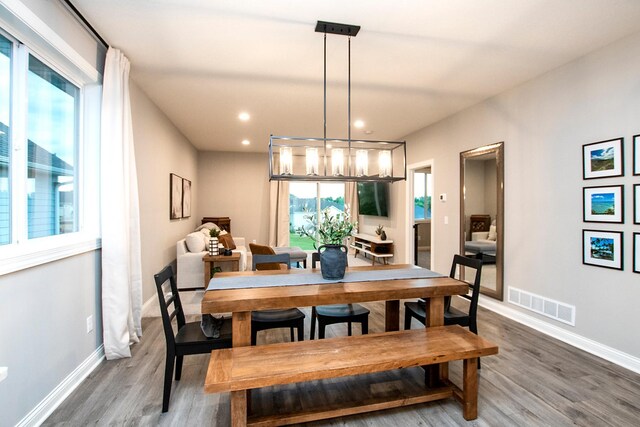 dining area featuring plenty of natural light, dark hardwood / wood-style floors, and an inviting chandelier