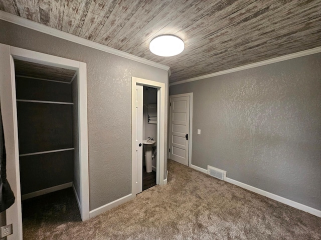 unfurnished bedroom with crown molding, carpet flooring, a closet, and wooden ceiling