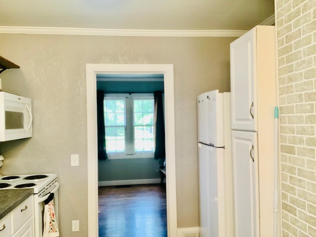 kitchen with crown molding, white cabinetry, white appliances, wood-type flooring, and brick wall