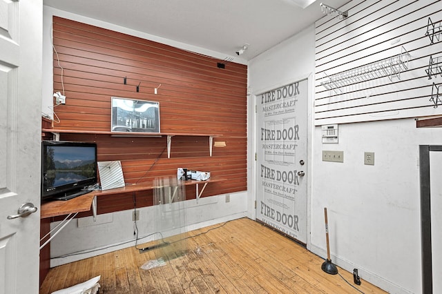 office space featuring light wood-type flooring and wood walls