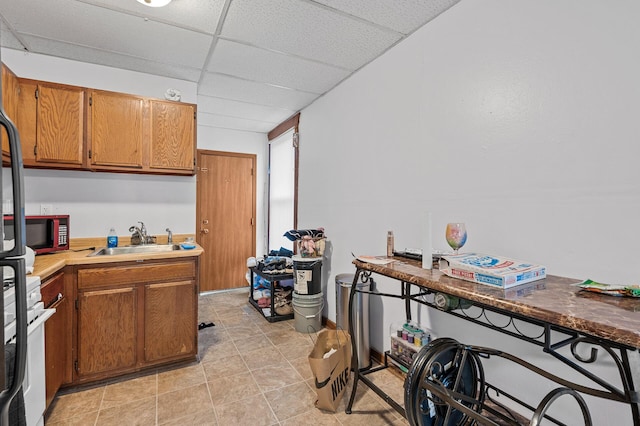 kitchen featuring a paneled ceiling, light tile patterned flooring, sink, and white electric range