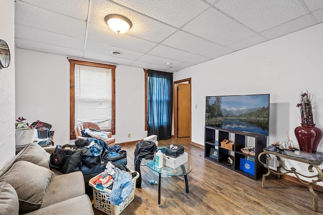 living room with a paneled ceiling and hardwood / wood-style floors