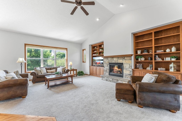 living room featuring vaulted ceiling, a fireplace, carpet floors, ceiling fan, and built in shelves