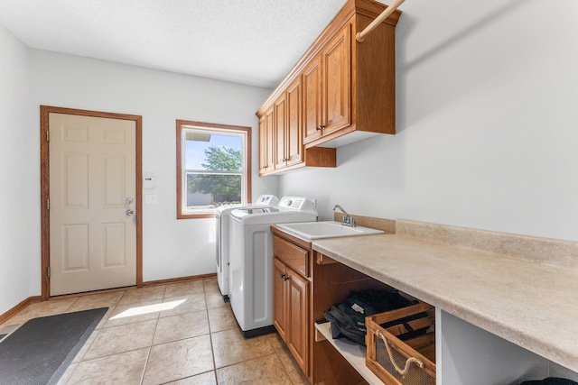 laundry room featuring cabinets, light tile patterned floors, and washer and dryer